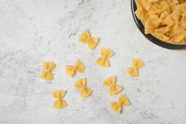 Pasta farfalle in glass bowl on white background. 