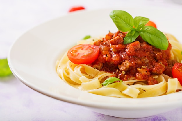 Free photo pasta fettuccine bolognese with tomato sauce in white bowl.