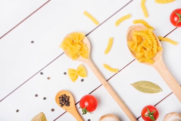 Free photo pasta ingredients on white wooden table