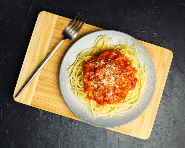 Pasta plate on chopping board with fork