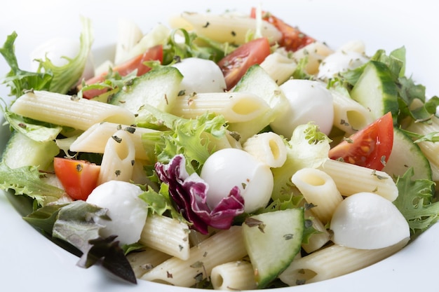 Free photo pasta salad with vegetables and mozzarella cheese isolated on white background