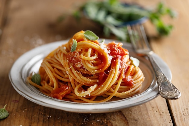 Pasta spaghetti with tomato sauce and cheese served on plate