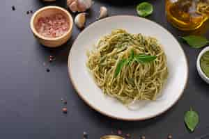 Free photo pasta spaghetti with zucchini, basil, cream and cheese on black stone table.