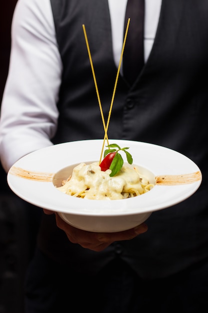 Free photo pasta with melted cheese and cherry tomato on top