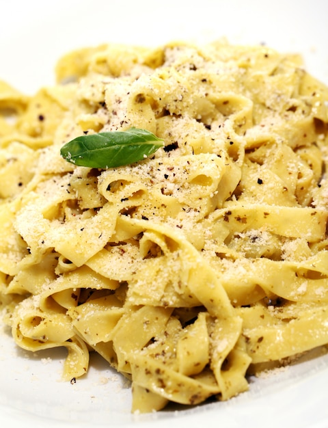 Free photo pasta with parmesan cheese and basil leaf