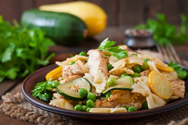 Free photo pasta with zucchini, chicken and green peas