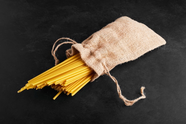 Pastas on black in a burlap parcel.