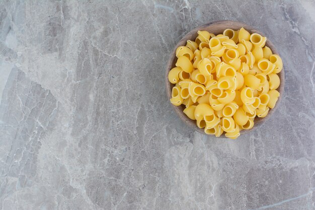 Pastas isolated in a rustic wooden plate on the marble