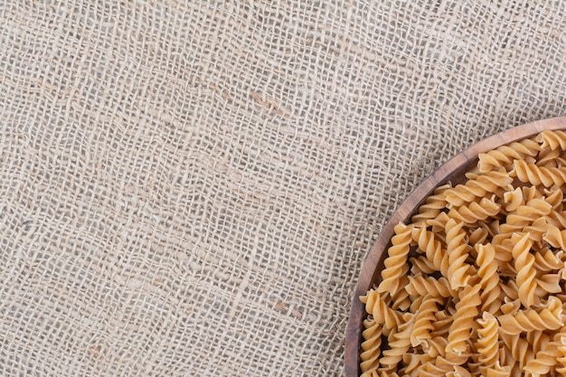 Pastas isolated in a rustic wooden plate on the marble