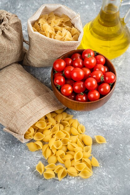 Pastas served with cherry tomatoes and a bottle of extra virgin olive oil.