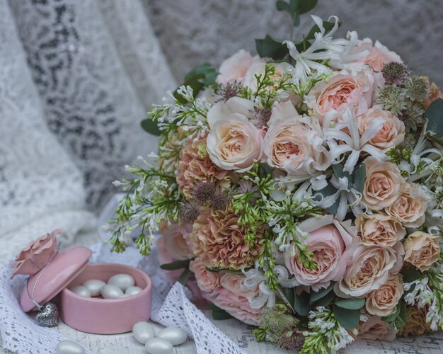 Pastel color bridal bouquet, wedding dress and candy jar