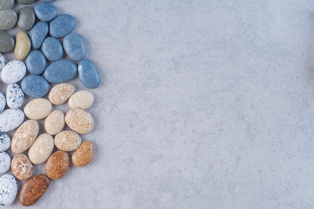 Free photo pastel color stones for crafting on concrete background.