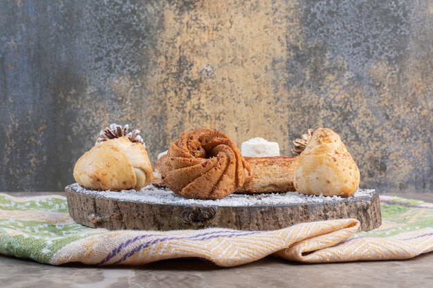 Pastry assortment on a wooden board on marble.