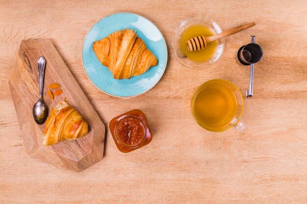 Pastry croissant with honey flat lay