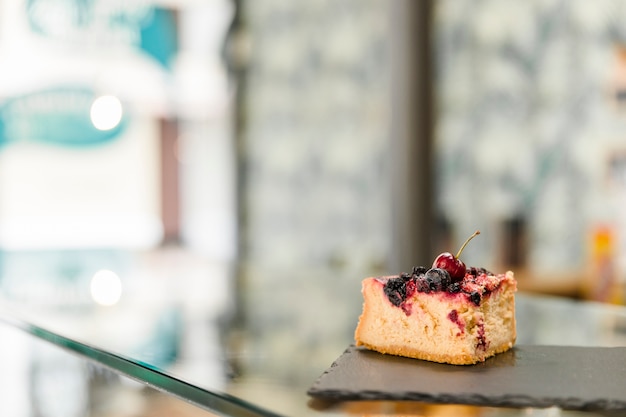 Free photo pastry on shale board over glass counter