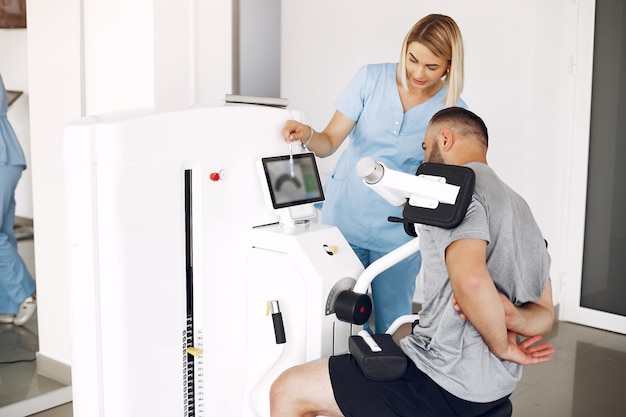 Free photo patient doing exercise using sports equipment with therapist