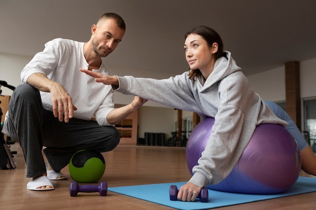 Patient doing physical rehabilitation helped by therapists