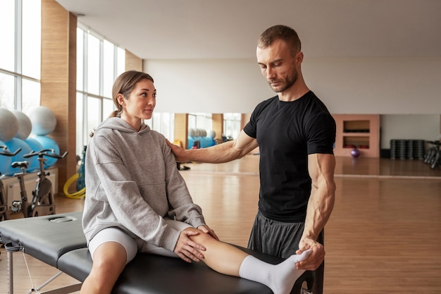 Patient doing physical rehabilitation helped by therapists