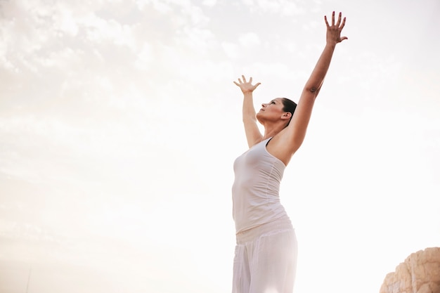 Peaceful woman stretching arms towards the sky