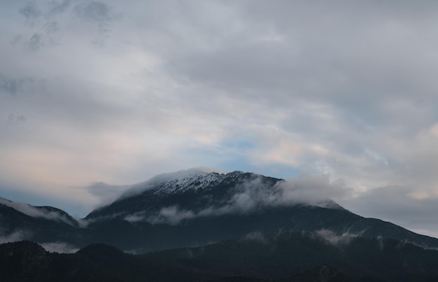 The peaks of the mountains in the snow shrouded in clouds natural background the idea of a landscape about winter on the Mediterranean coast