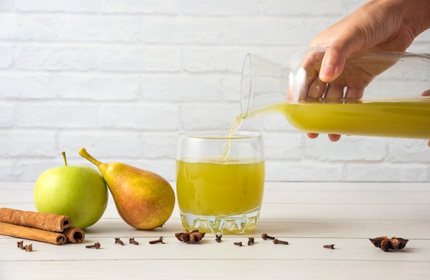 Free photo pear and apple juice with cinnamon flavour in glass cup