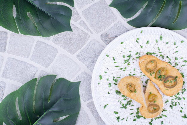 Pear slices served with green olives and herbs.