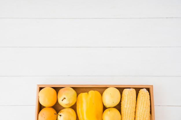 Free photo pears; bell pepper and corn on wooden tray over the white table