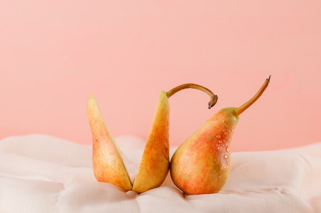 Pears on pink and textile surface