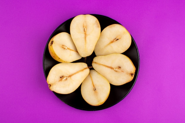 Free photo pears round shaped fresh ripe fruits inside black plate on a purple desk