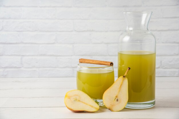 Pears with a glass jar of juice and cinnamon sticks