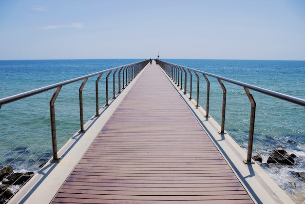 Free photo pedestrian bridge by the beach in barcelona, spain