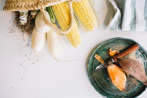 Peeled yam near corn and radish