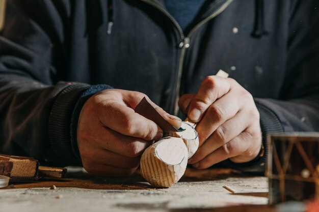 Peeling mini wooden crafts in the atelier