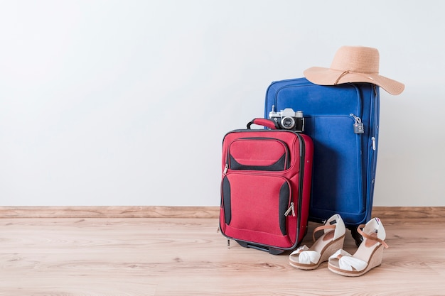 Free photo peep-toe shoes and hat near suitcases and camera