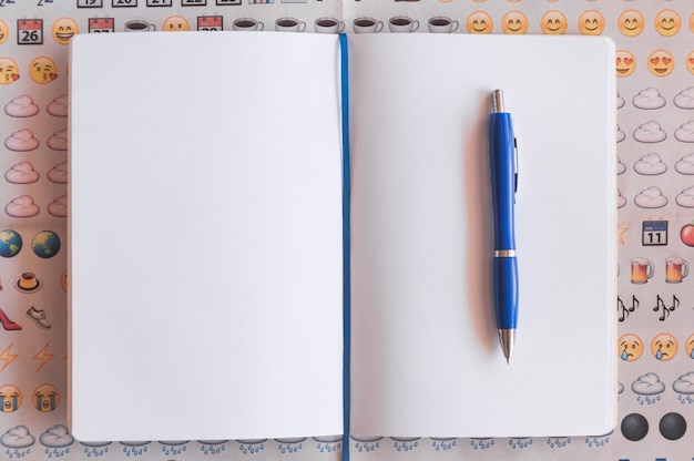 Free photo pen and notebook on emoji background