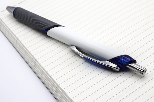 Pen put on an open notebook with horizontal lines