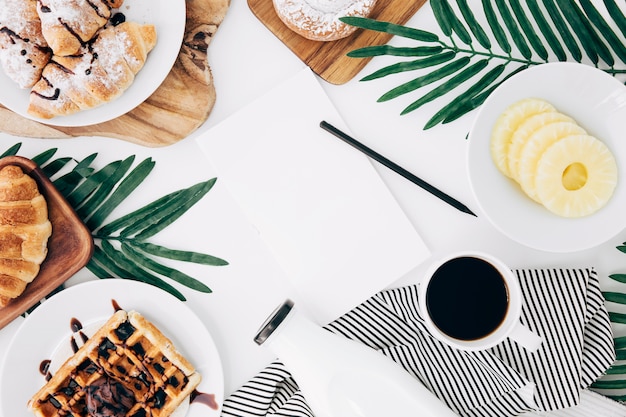 Pencil and blank paper in the center of the breakfast on white desk