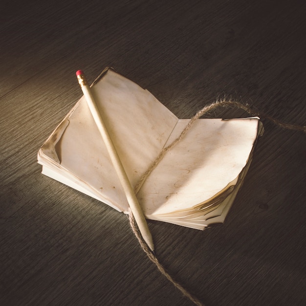 Pencil and linen thread on old notebook