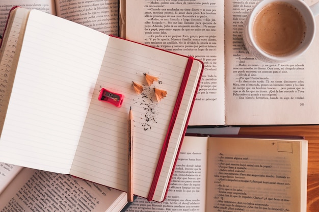 Free photo pencil and notebook near coffee and books