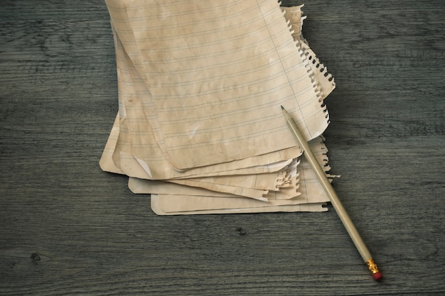 Free photo pencil and ruled paper on wooden tabletop