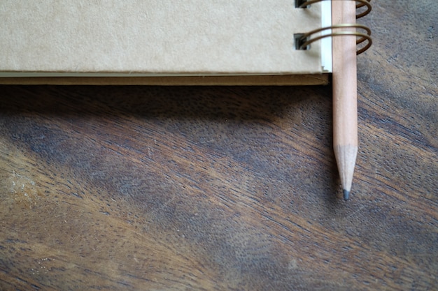 Free photo pencil with book on wood