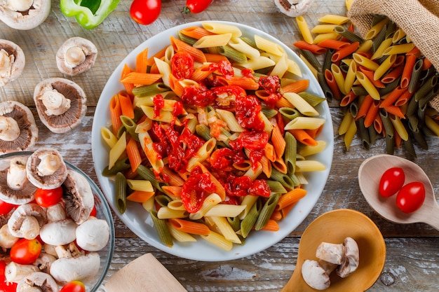 Penne pasta in a plate with sauce, tomato, mushroom, pepper