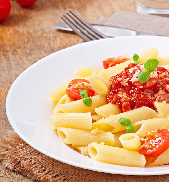 Penne pasta with bolognese sauce, parmesan cheese and basil