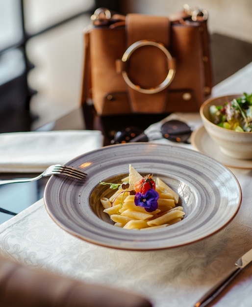 Penne pasta with parmesan in a ceramic plate in a luxury restaurant