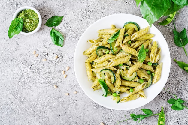 Free Photo penne pasta with  pesto sauce, zucchini, green peas and basil. italian food. top view. flat lay.