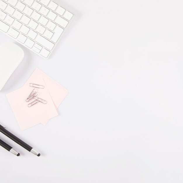 Pens and sticky notes near keyboard and mouse