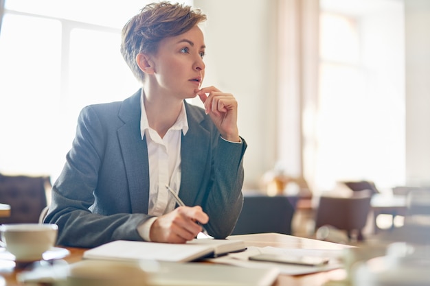 Pensive Businesswoman at Coffeehouse