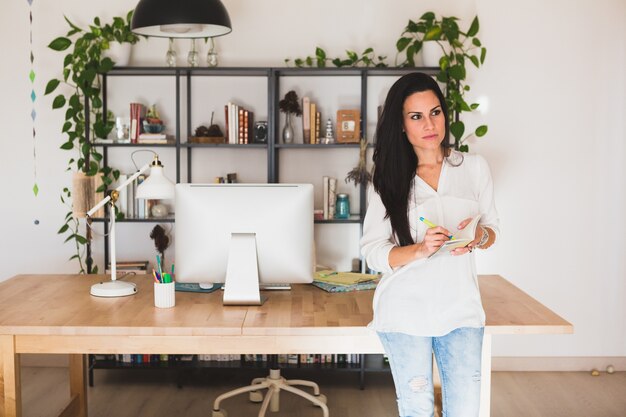 Pensive employee with a notebook in hands