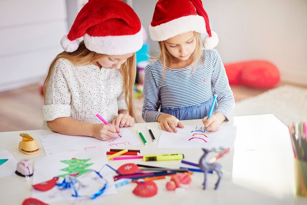 Pensive girls drawing christmas paintings