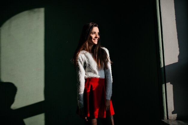 Pensive long-haired woman expressing happines during indoor photoshoot